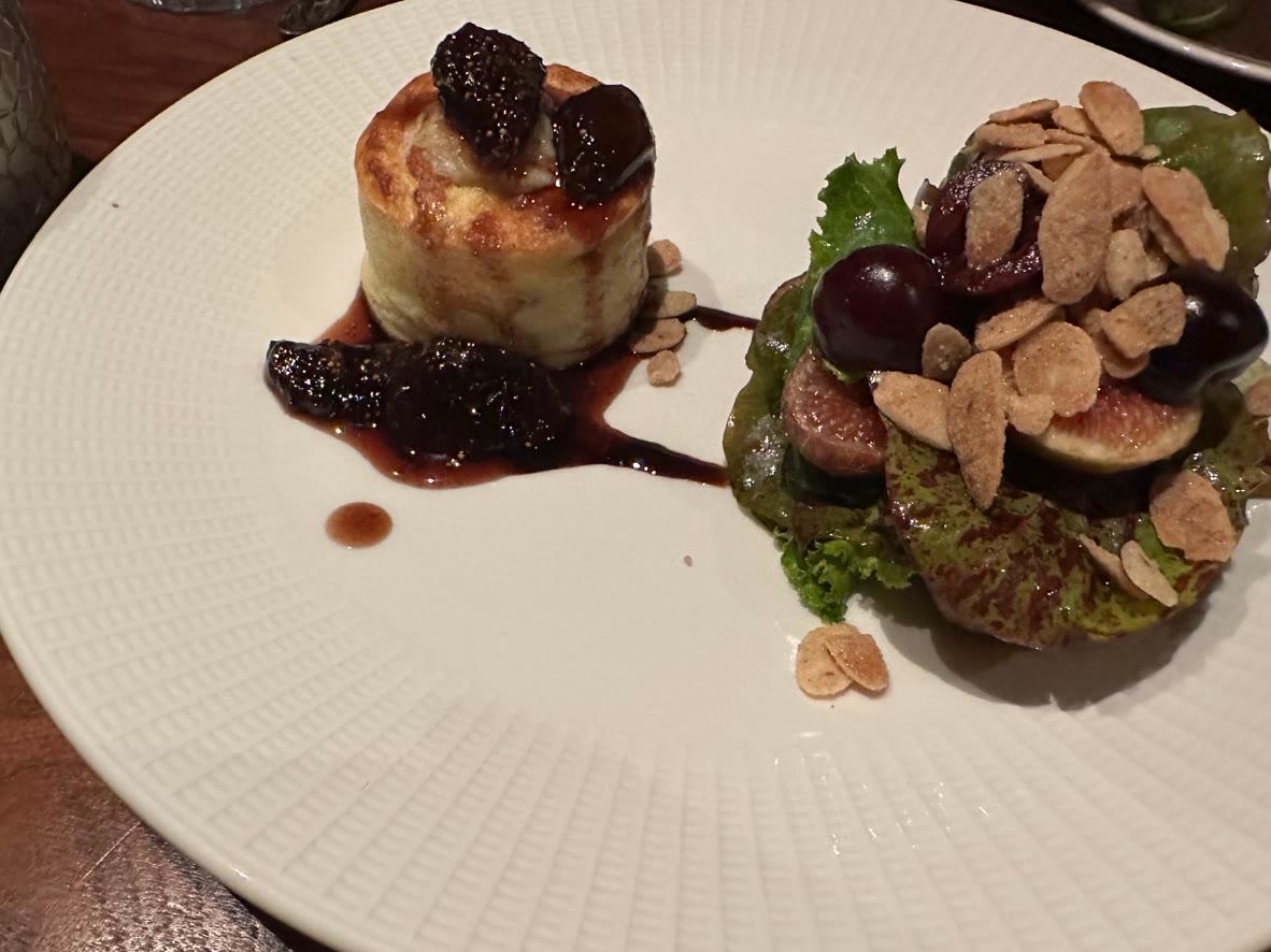 An individual blue cheese soufflé with honeyed figs, grapes, almonds, and greens