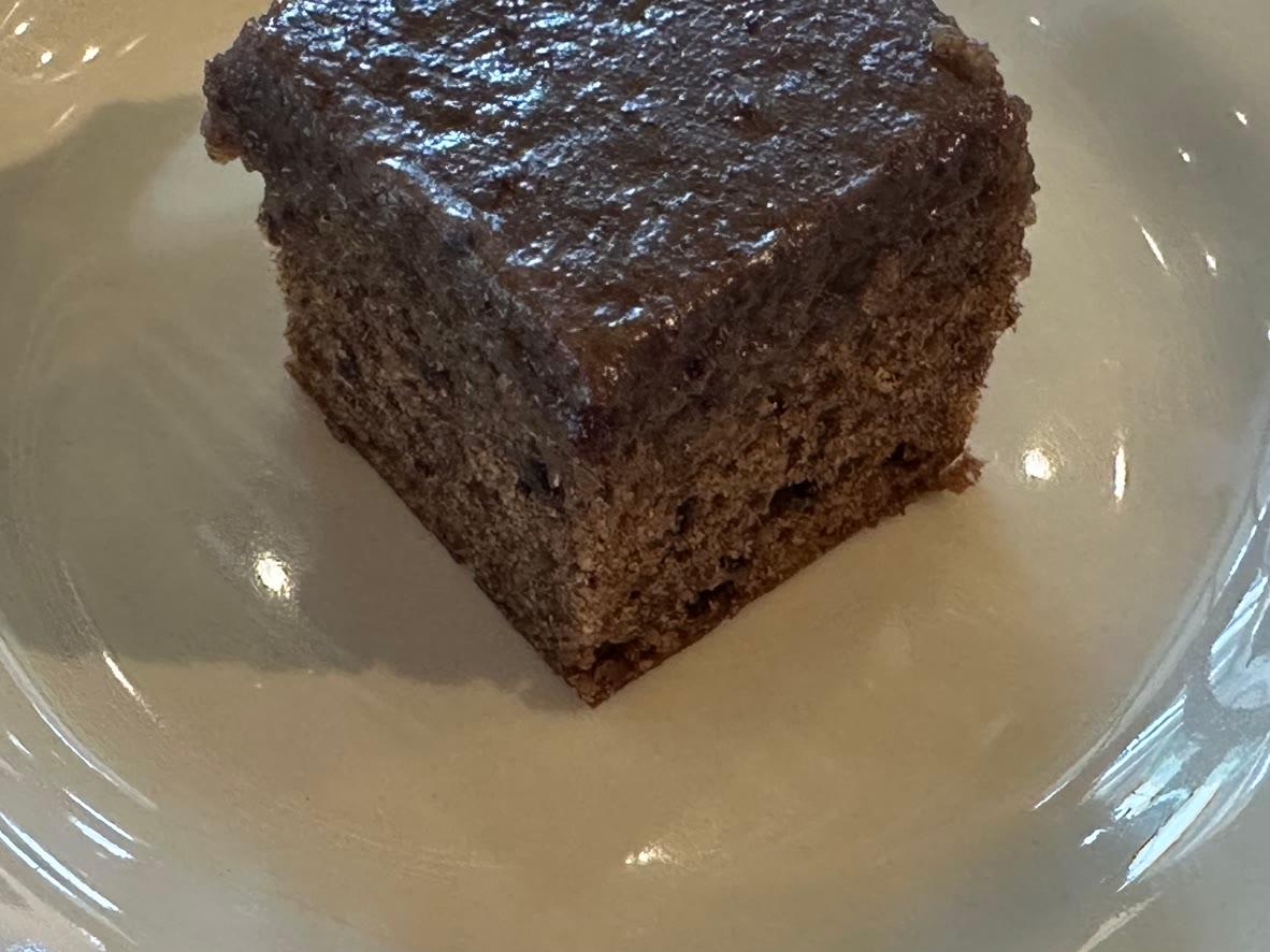 Small square of carrot tea cake covered with dark sticky-toffee glaze