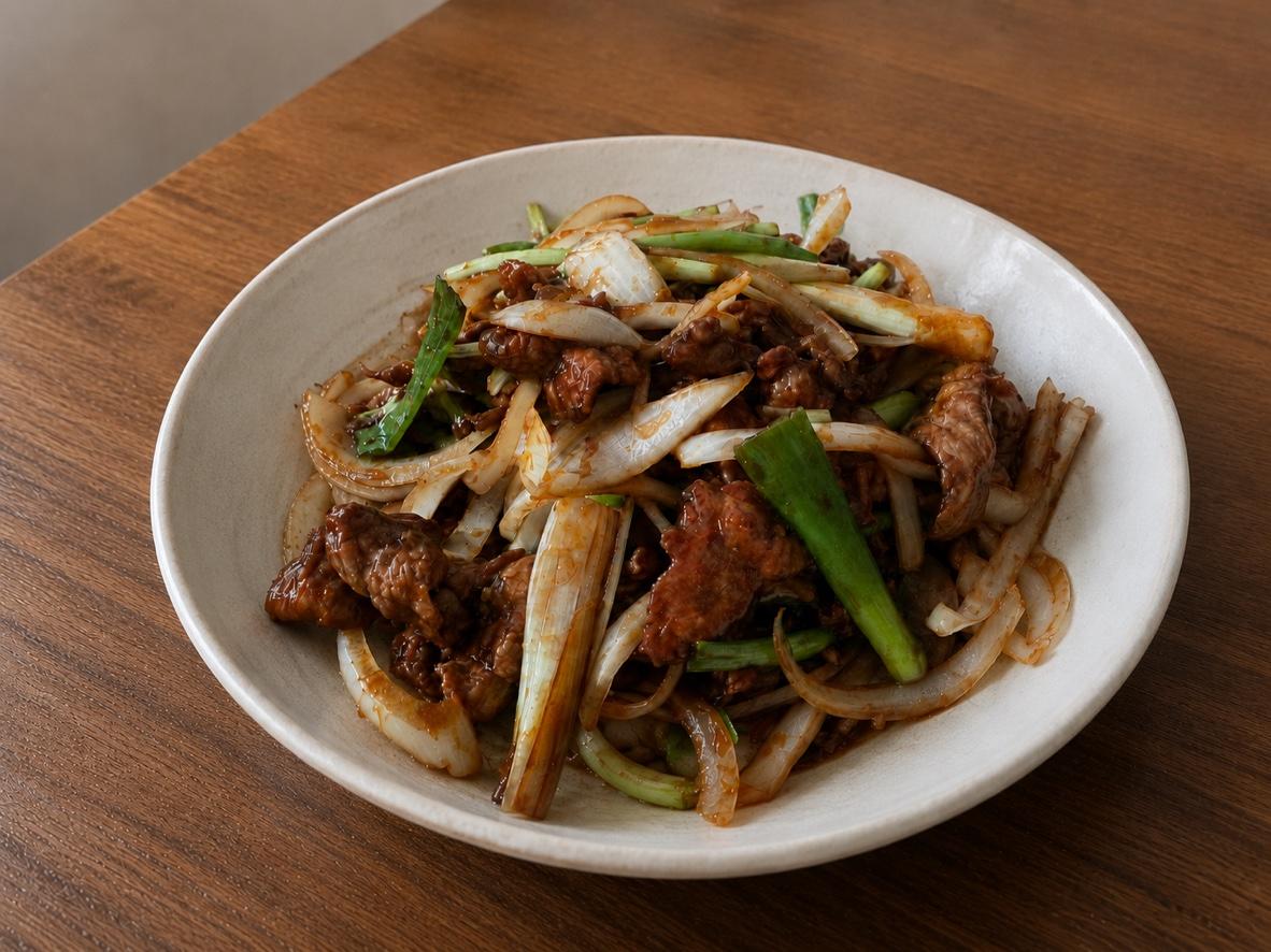 Chinese beef and onion stir-fry with scallions in a glossy brown sauce