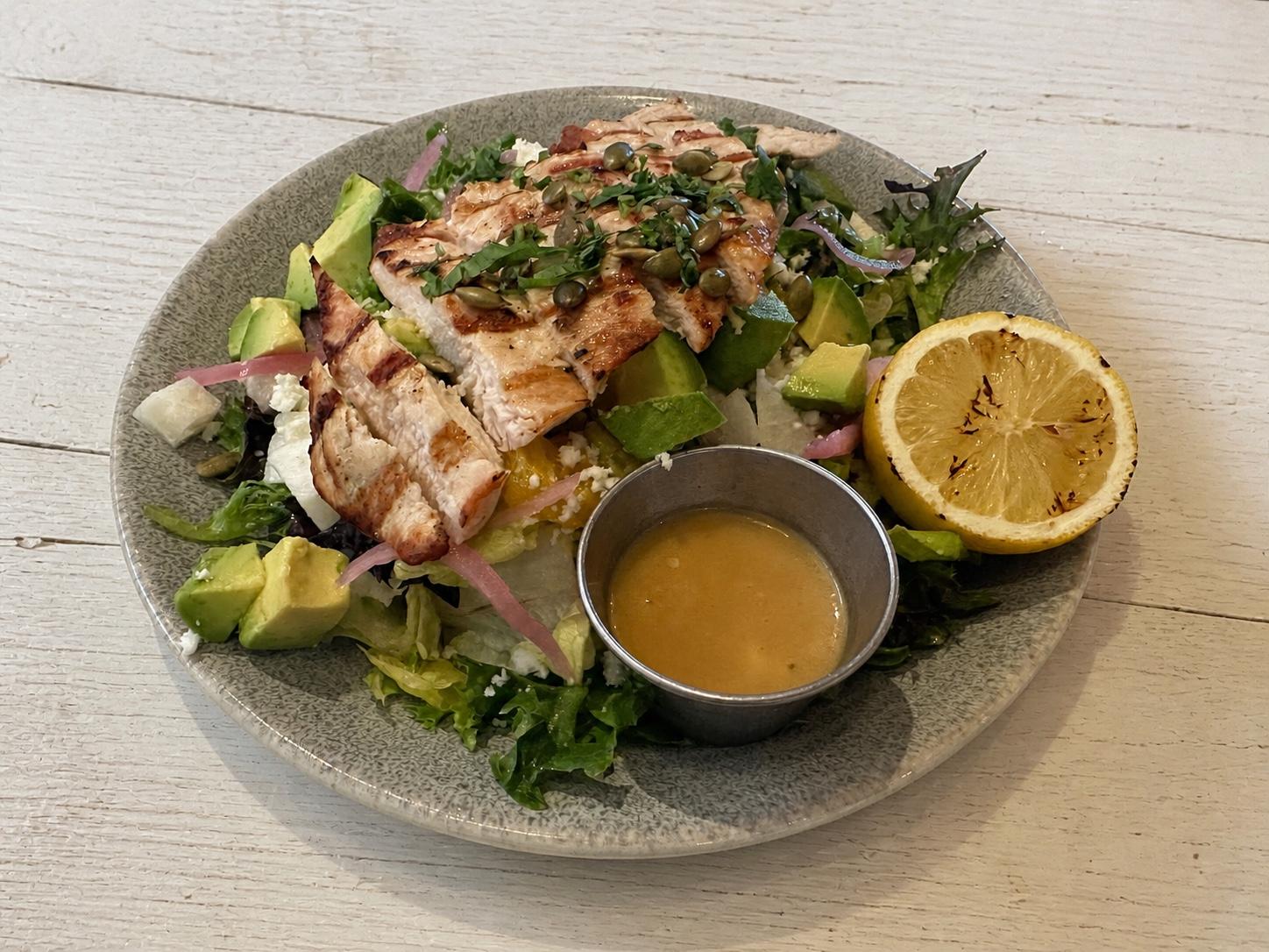 Grilled chicken citrus-pepita salad with avocado, orange, jicama, queso fresco, quinoa, and mango vinaigrette