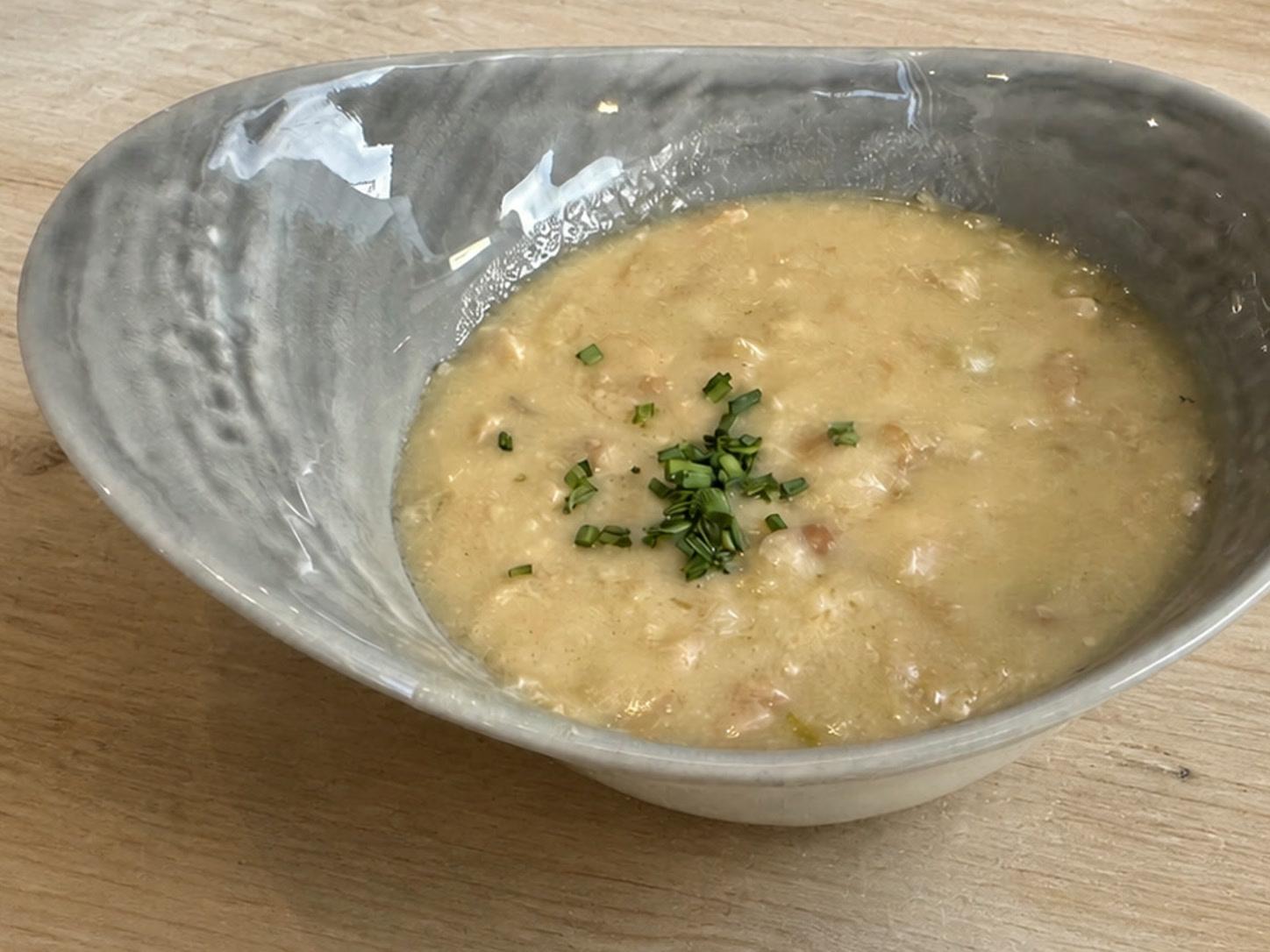 Creamy New England fish chowder with white fish, potatoes, bacon, and chopped chives