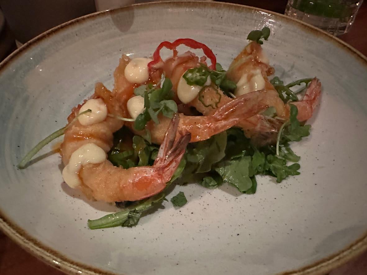 Crispy shrimp tempura over green papaya salad with herbs and chili mayonnaise