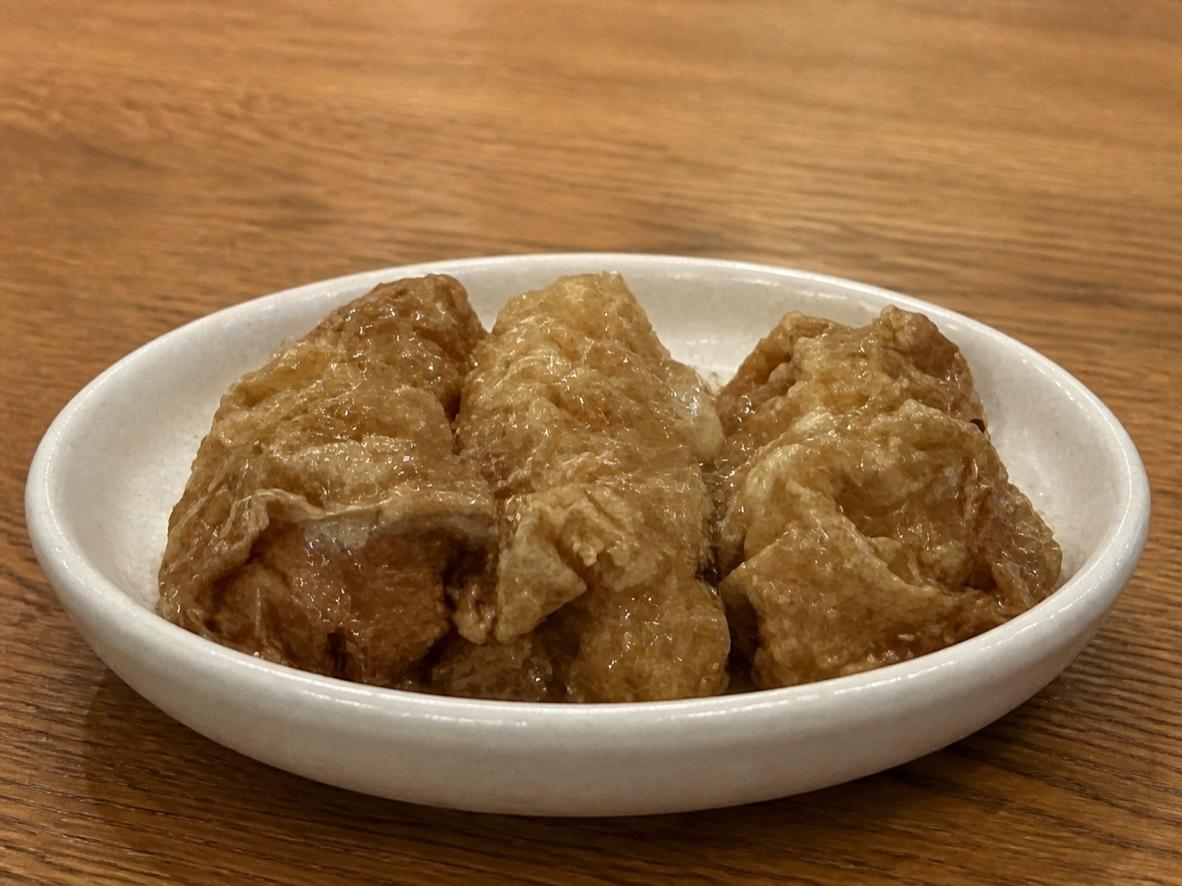 Cantonese steamed tofu skin rolls glazed with oyster sauce on a ceramic plate