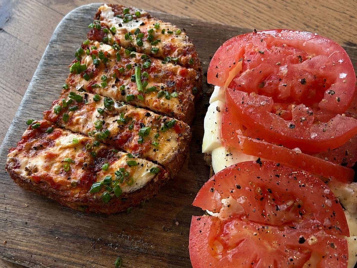 Goat cheese toast with pepper topping beside tomato mozzarella bruschetta