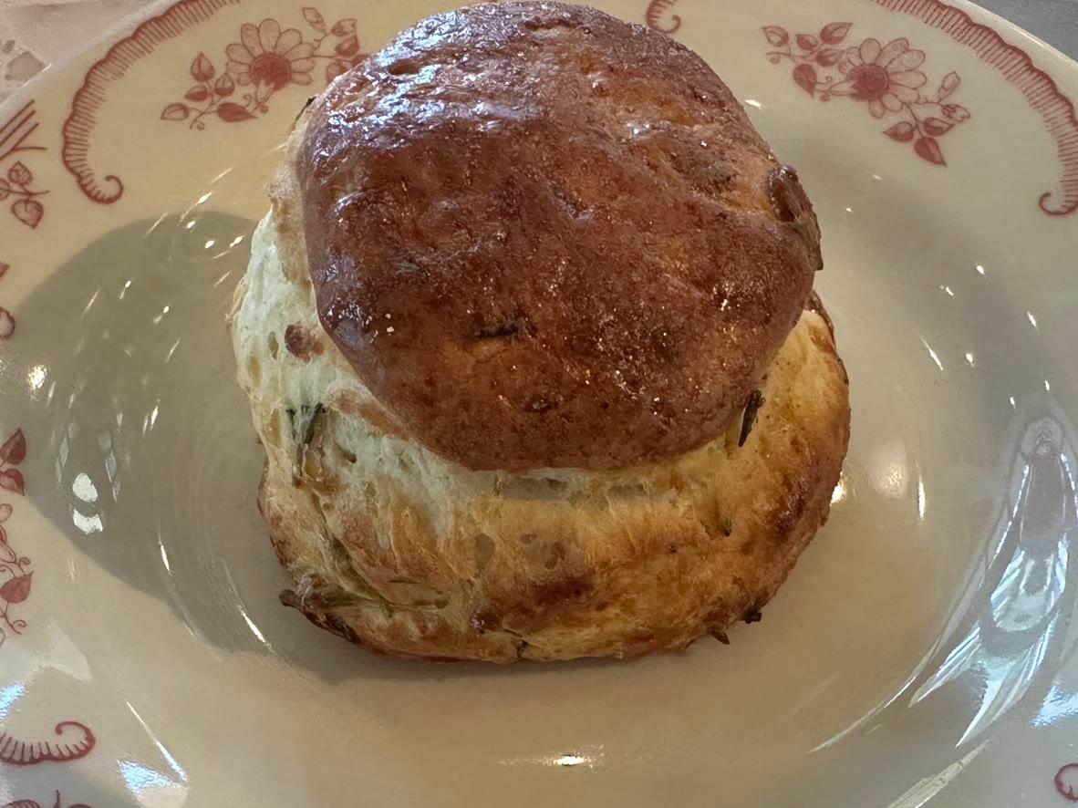 Tall round honey-lavender scone brushed with honey butter on a floral plate