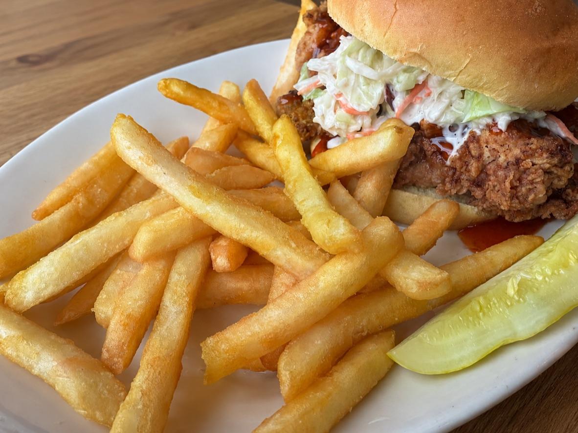 Hot honey fried chicken sandwich with pickles and a side of french fries