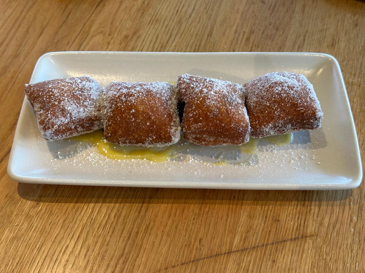 Sugar-coated Italian donuts served over lemon curd