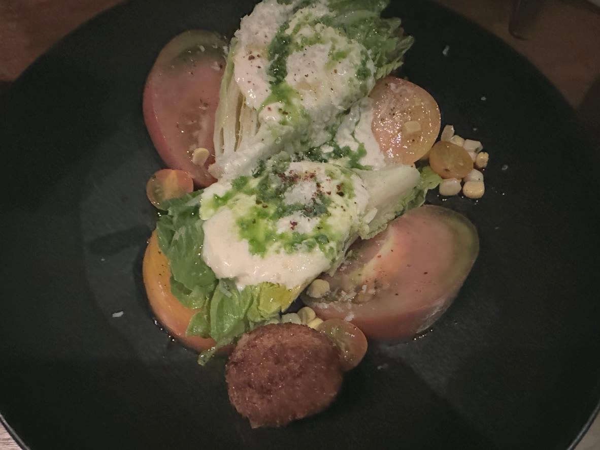 Little Gem lettuce with creamy pea dressing, heirloom tomatoes, corn, Parmesan, and basil oil