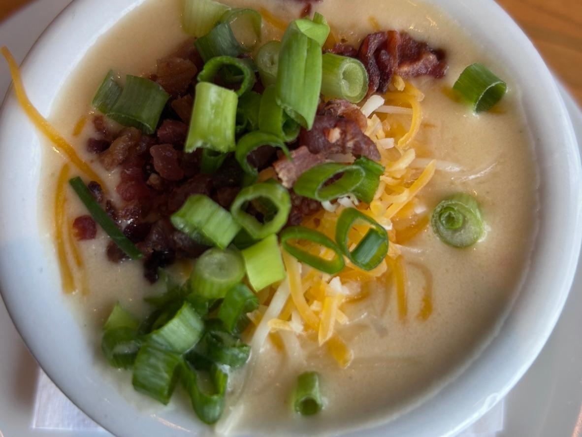 Creamy loaded baked potato soup topped with bacon, cheddar, and sliced green onions