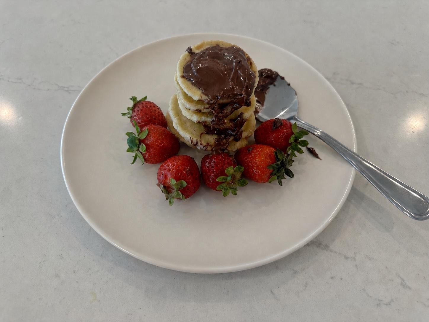 Small banana pancakes layered with Nutella and served with fresh strawberries