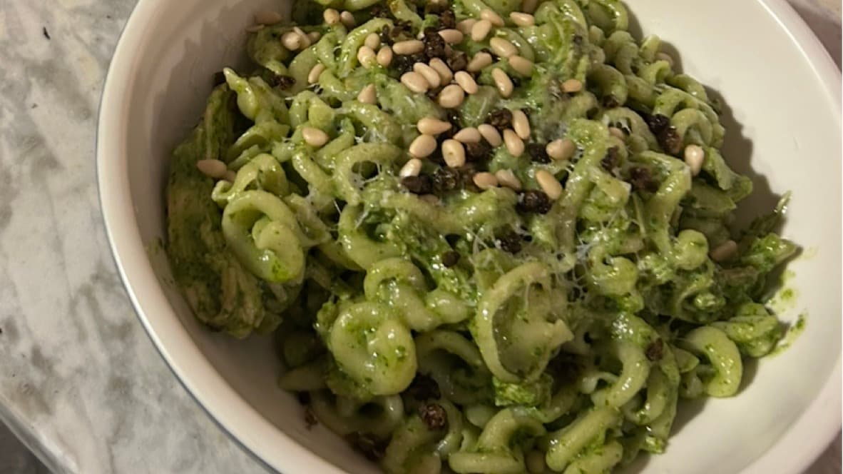 Curly pasta coated in basil pesto and topped with pine nuts and black pepper
