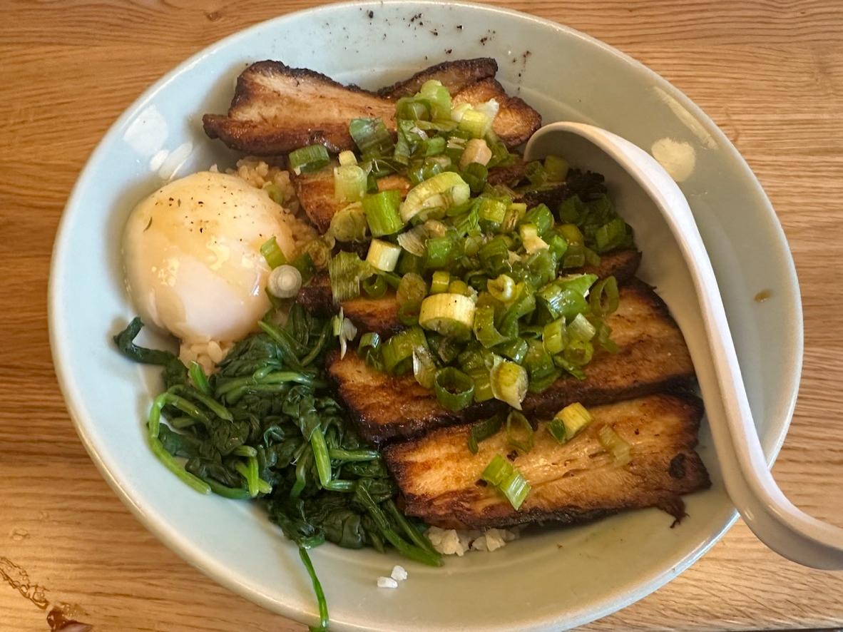 Glazed pork belly over rice with spinach, a jammy egg, and scallion sauce