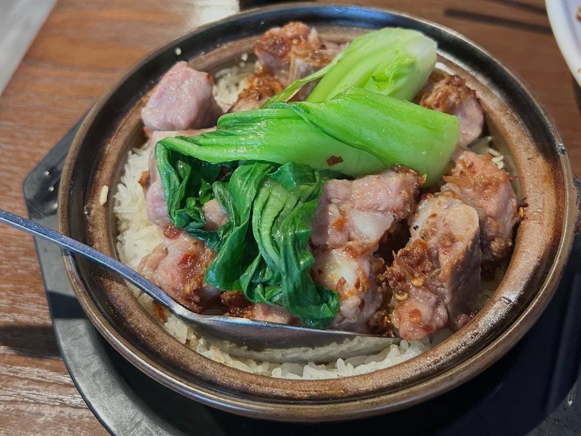 Pork rib claypot rice with bok choy in a black clay pot
