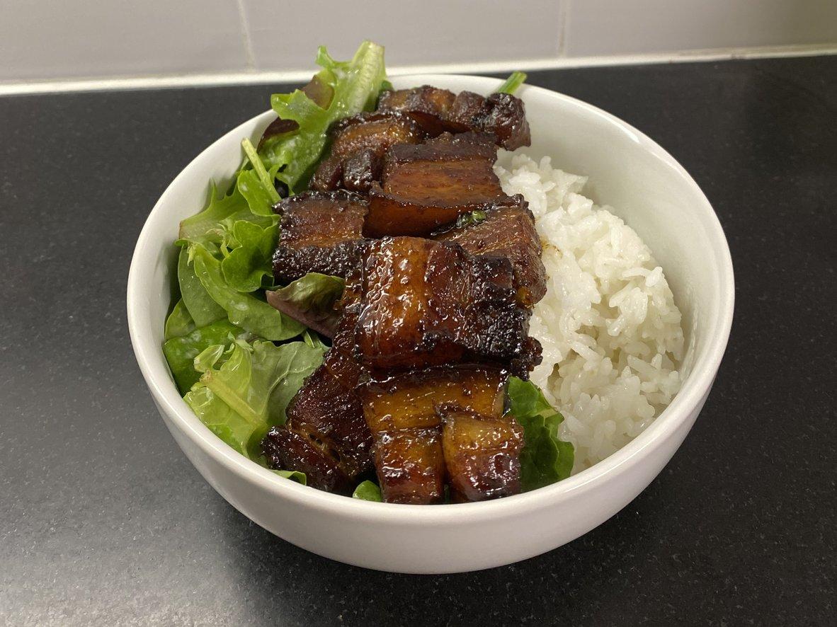 Lacquered red-braised pork belly over white rice with green vegetables