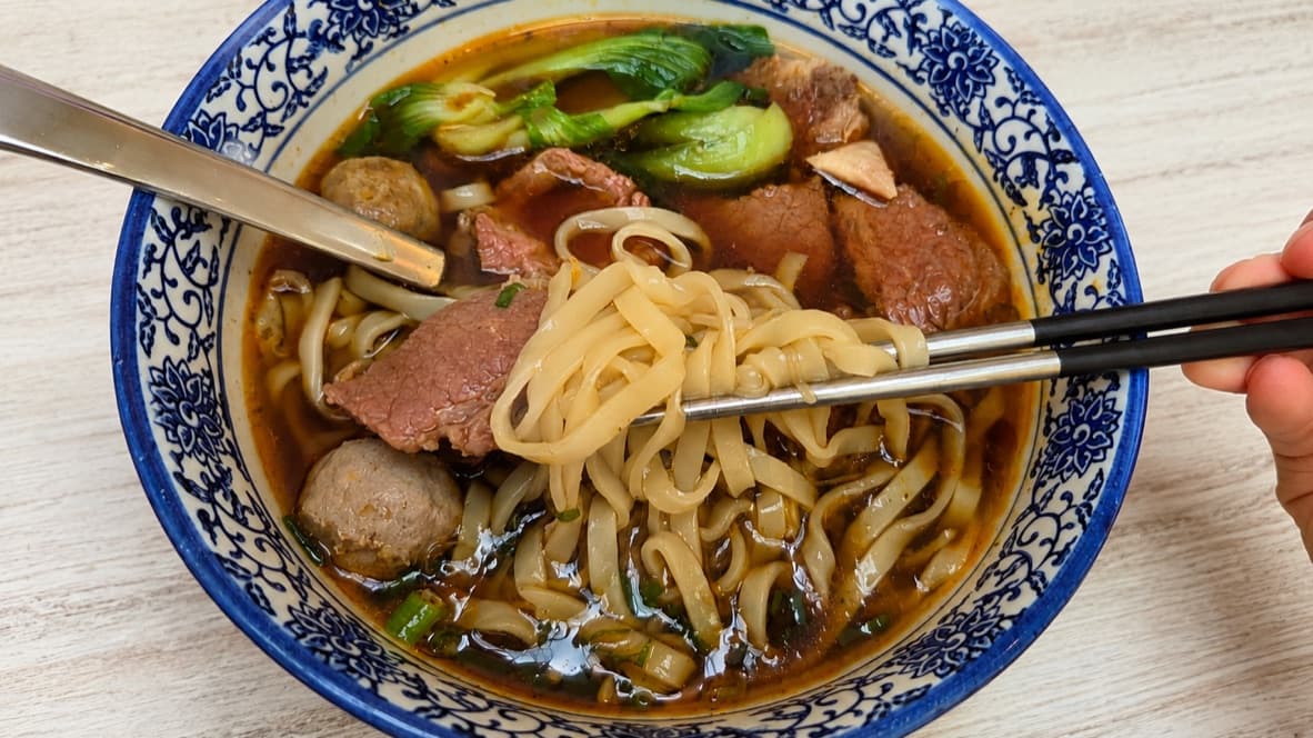 Taiwanese beef noodle soup with sliced beef, beef balls, noodles, and bok choy