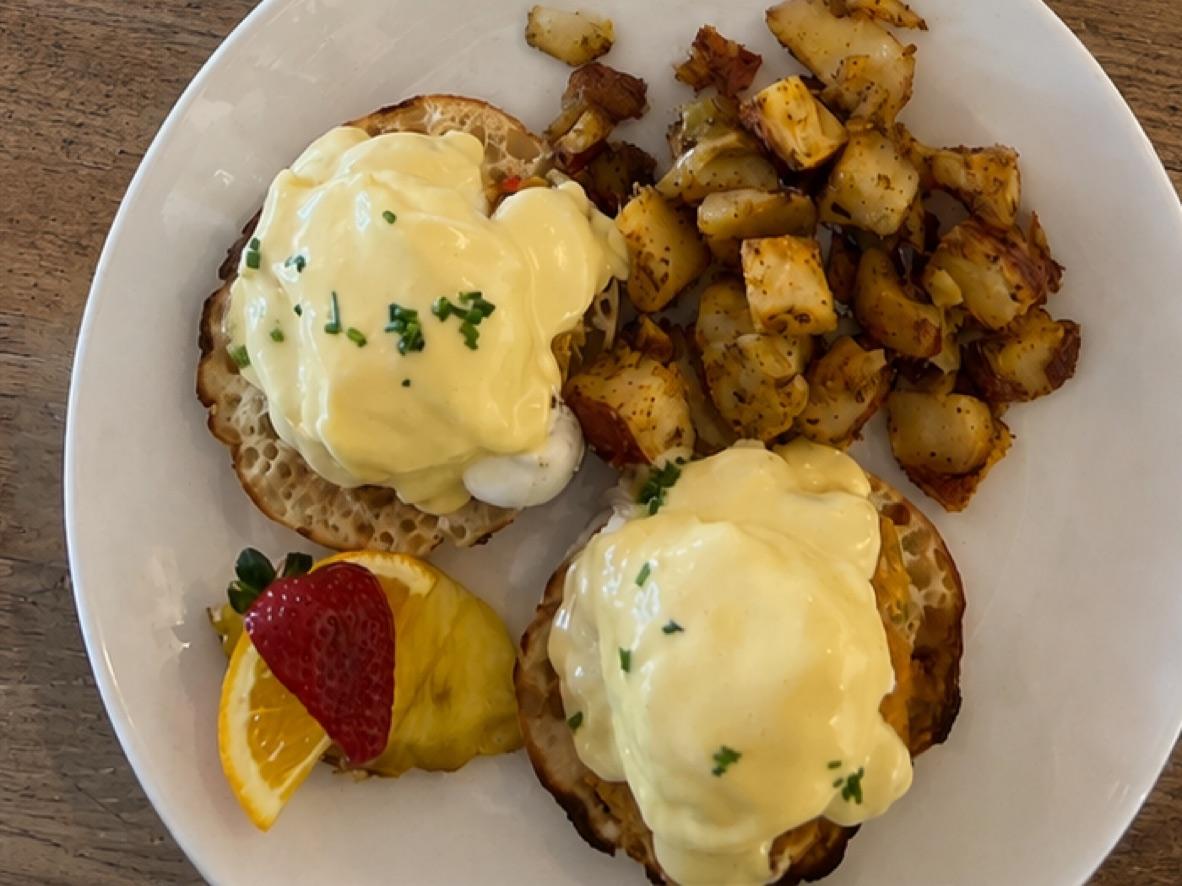 Two eggs Benedict with hollandaise and breakfast potatoes