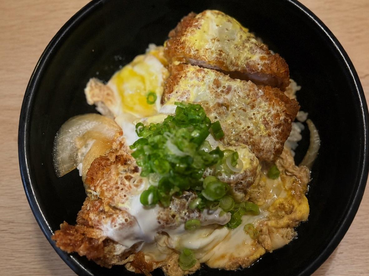 Katsudon with breaded pork cutlet, soft-cooked egg, onion, scallions, and rice