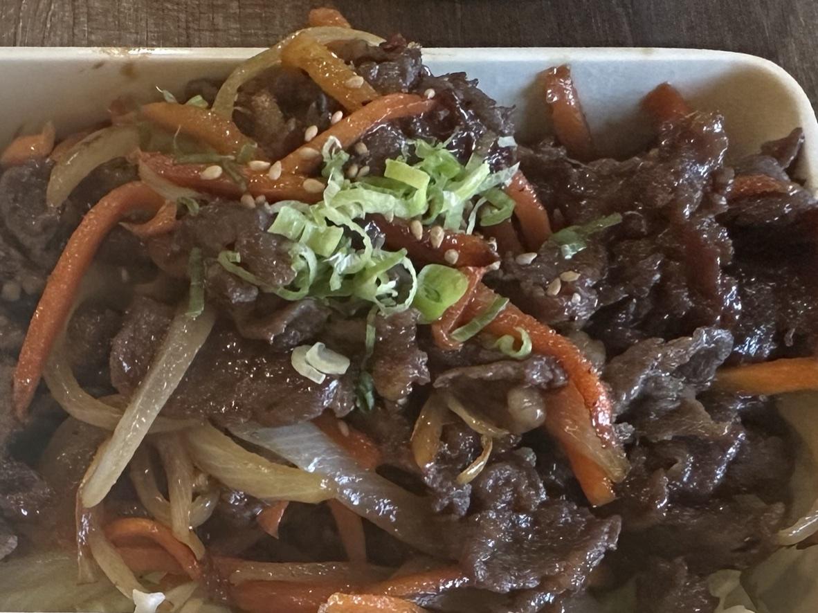 Korean beef bulgogi with onions, carrots, scallions, and sesame seeds