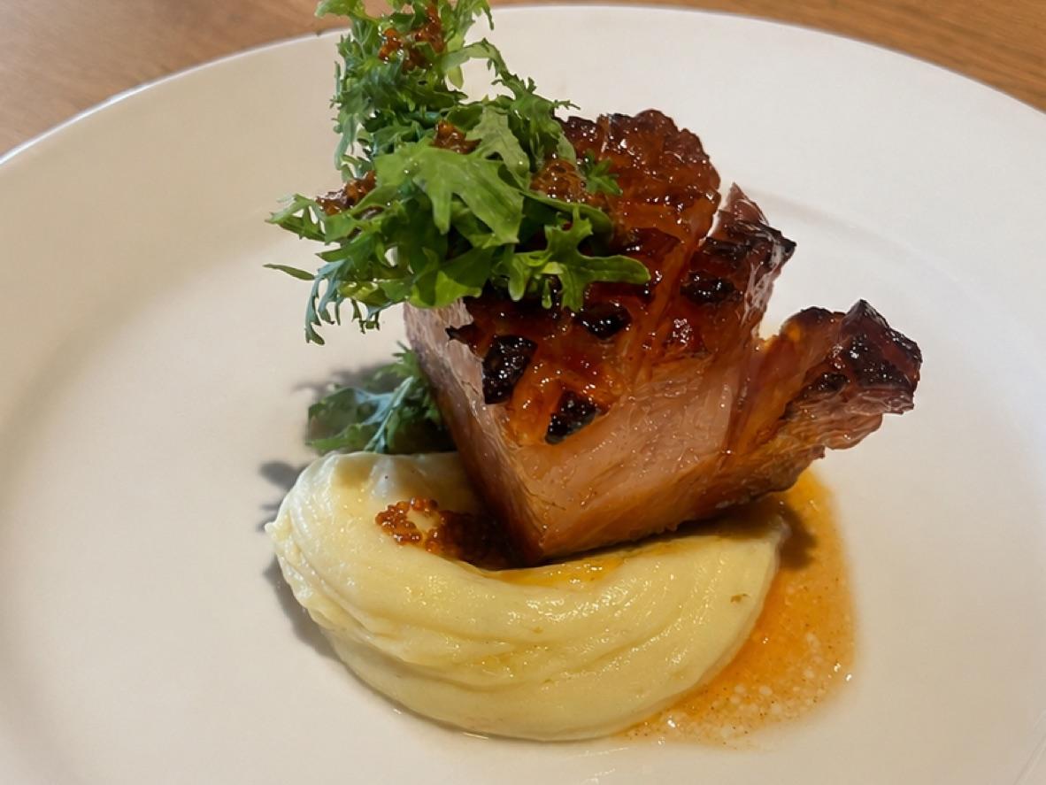 Glazed maple-Dijon pork chop over mashed potatoes with greens