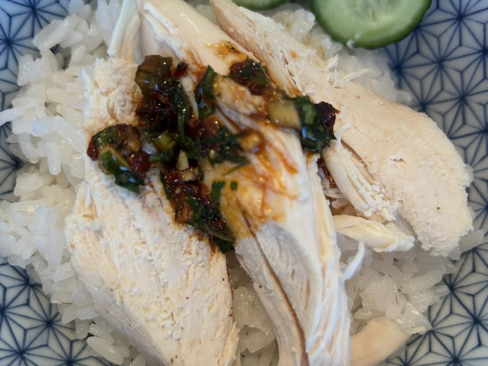 Sliced rotisserie chicken over rice with cucumbers and chili-crisp sauce