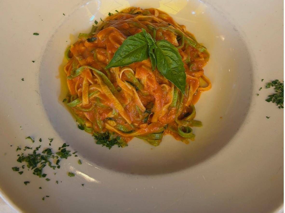 Tricolor tagliatelle twirled in tomato cream sauce and topped with basil